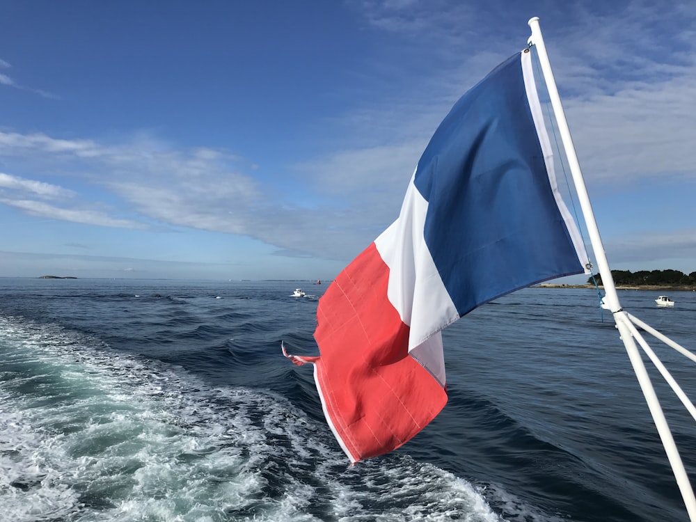 red white and blue flag on boat during daytime
