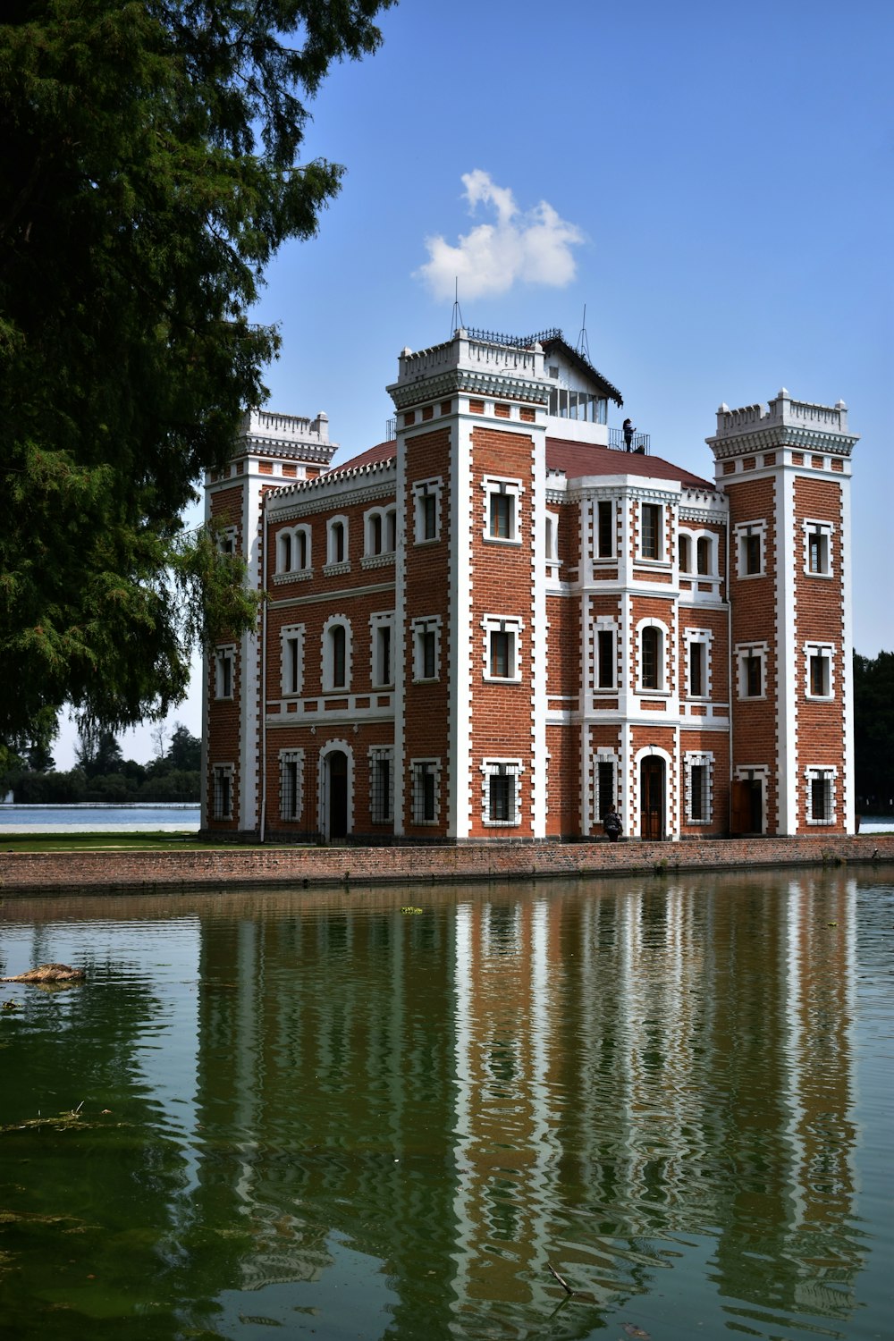 edificio in cemento marrone e bianco vicino allo specchio d'acqua durante il giorno