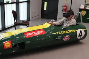 A relaxed learner practicing driving techniques using a virtual simulator setup.