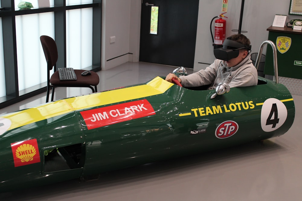 a man in a green race car with a virtual headset