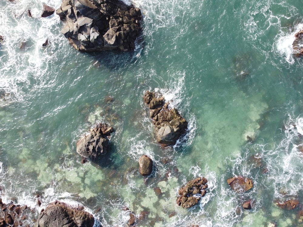 brown rocks on body of water during daytime