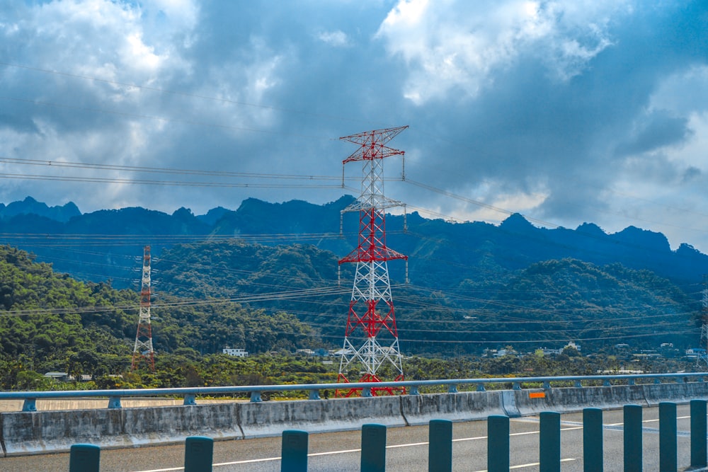 torre vermelha e branca perto da montanha verde sob o céu azul durante o dia
