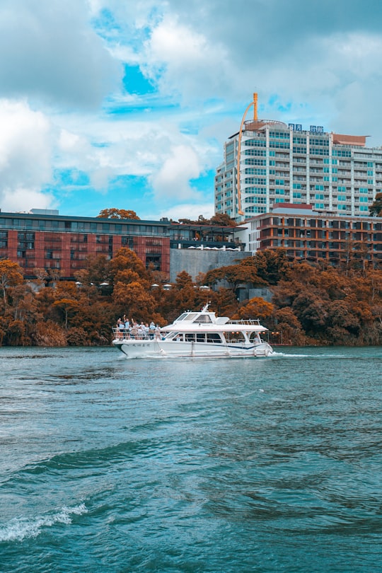 white yacht on body of water near brown concrete building during daytime in Sun Moon Lake Taiwan