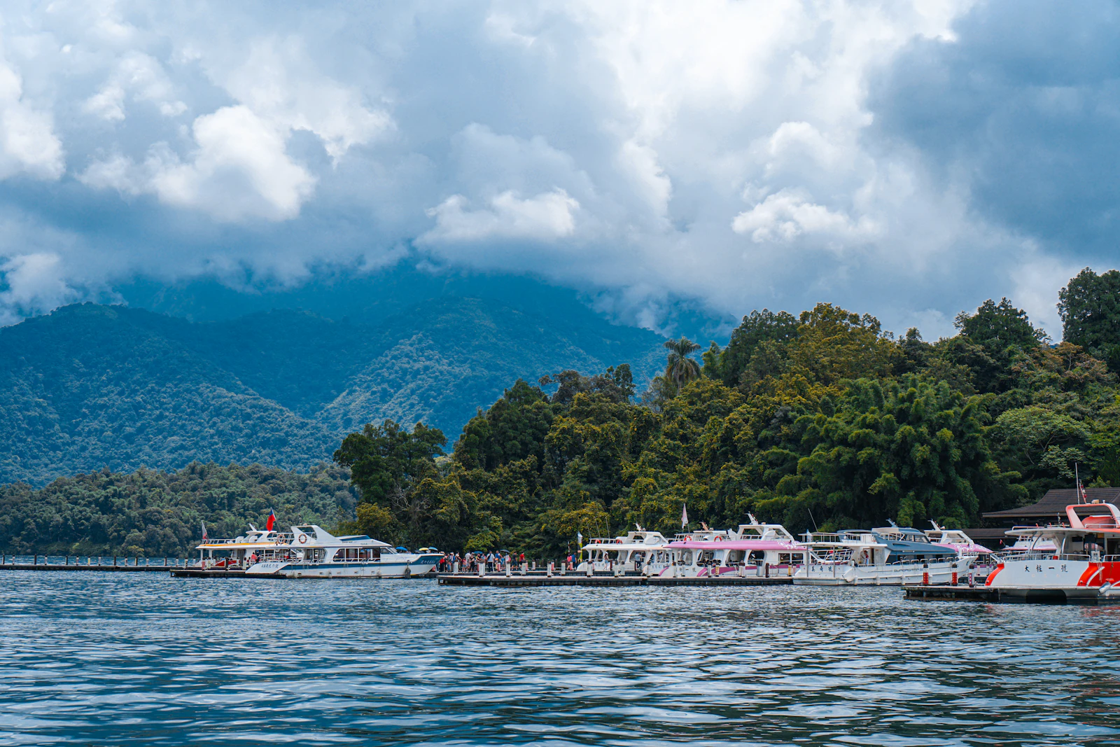 Boats and forested hills at Sun Moon Lake under low cloud