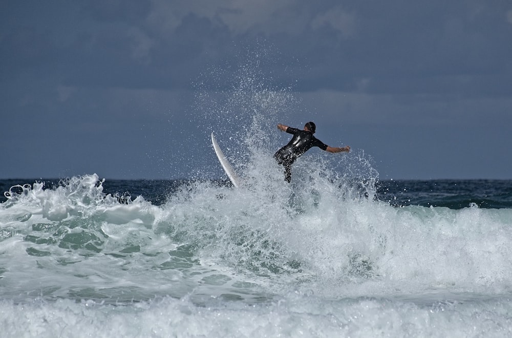 man surfing on sea waves during daytime