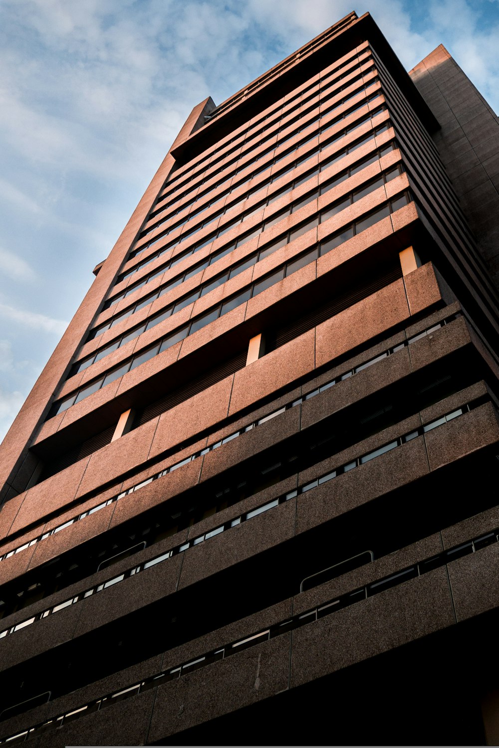 edifício de concreto marrom sob o céu azul durante o dia