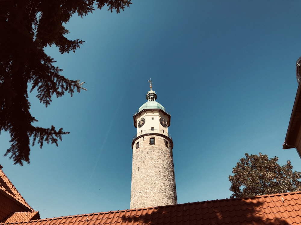 Leuchtturm aus weißem und braunem Beton tagsüber unter blauem Himmel