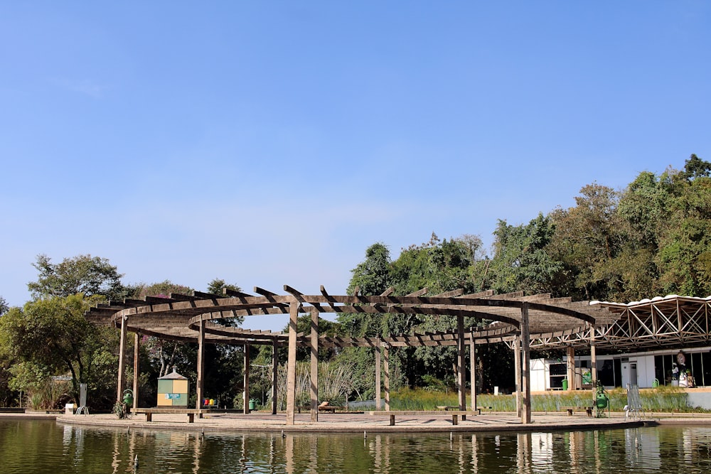 brown wooden gazebo near body of water during daytime