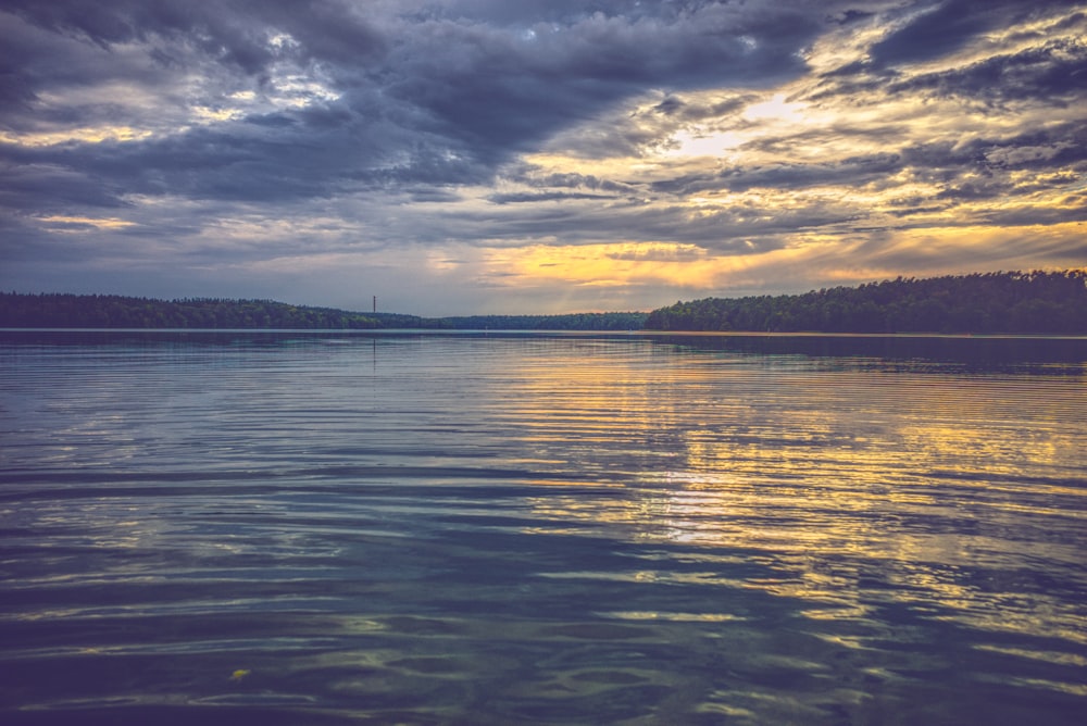 body of water under cloudy sky during daytime