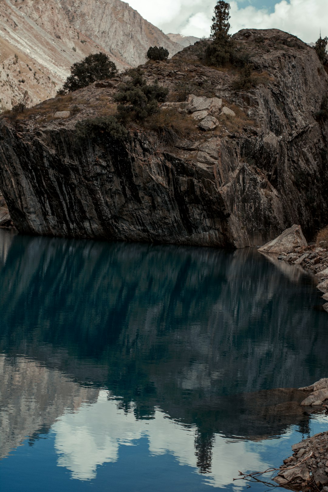 brown rocky mountain beside blue water