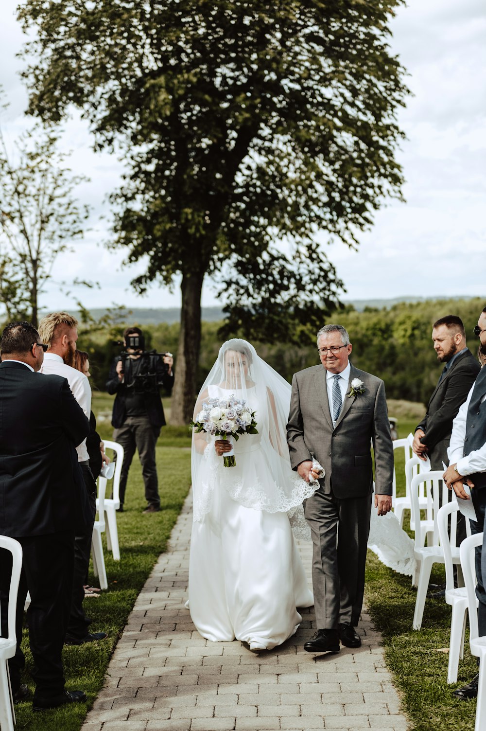 man in black suit and woman in white wedding dress walking on sidewalk during daytime