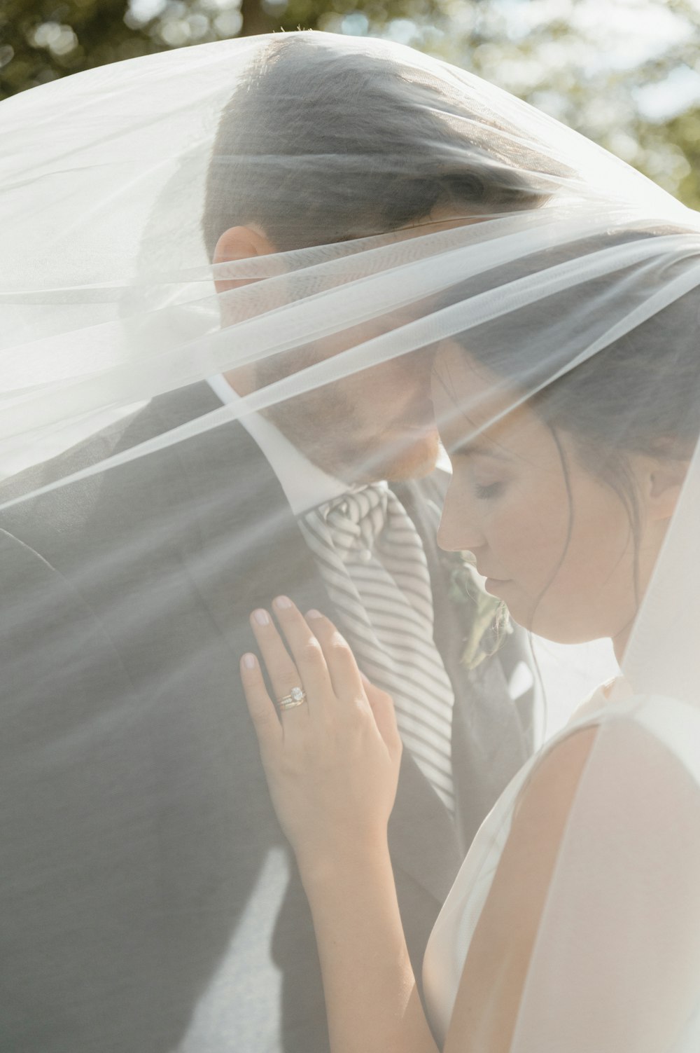 woman in white dress shirt covering her face with white veil