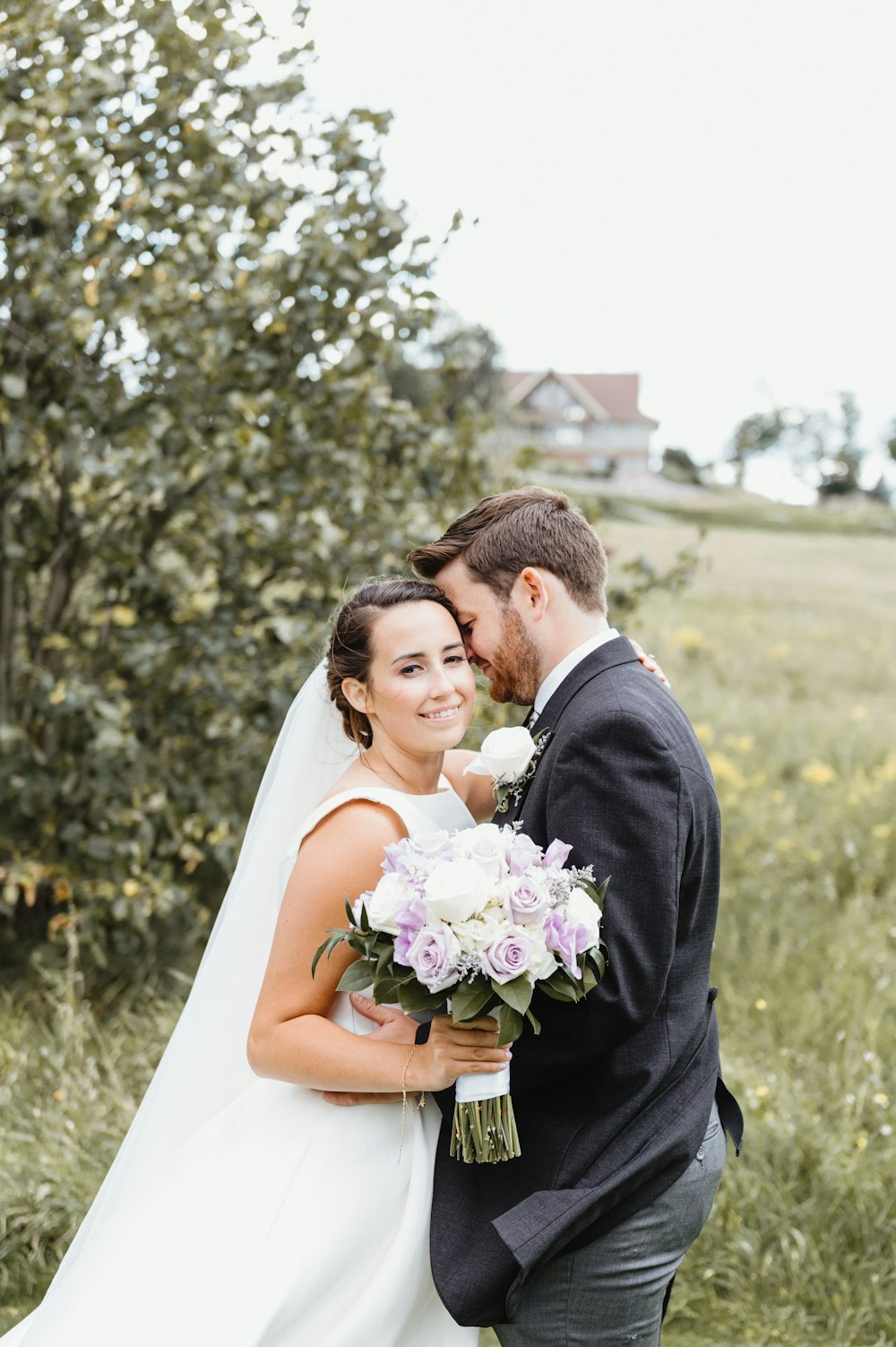 man in black suit kissing woman in white wedding dress