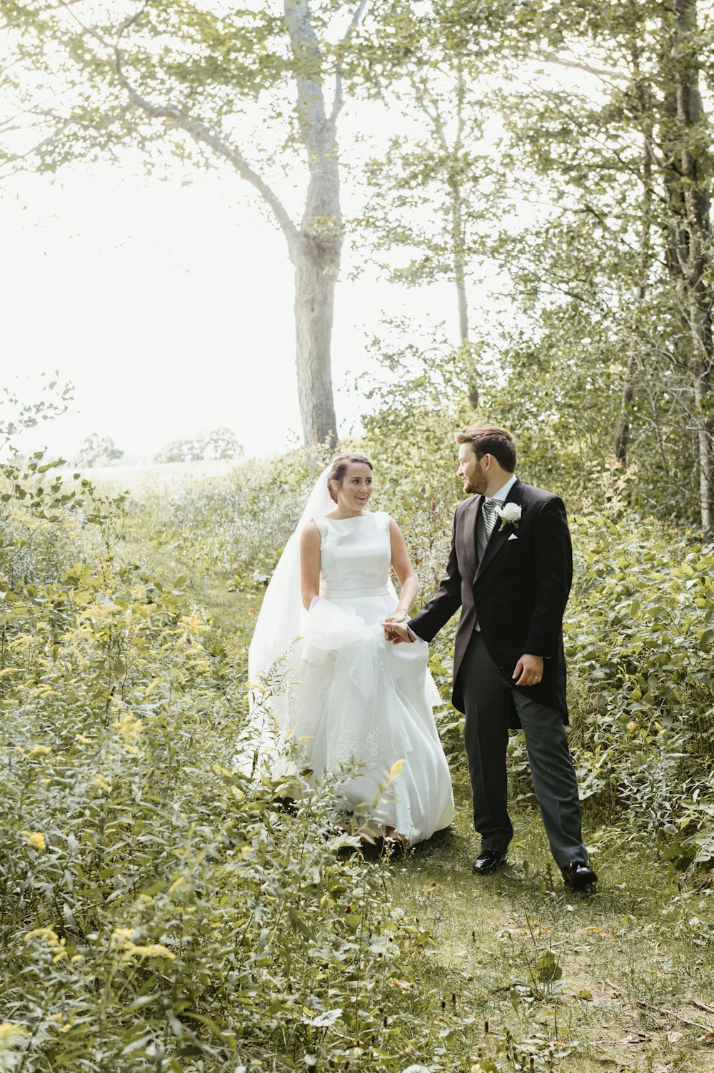 bride and groom standing on green grass field during daytime