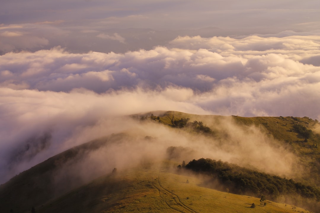 white clouds over green mountain