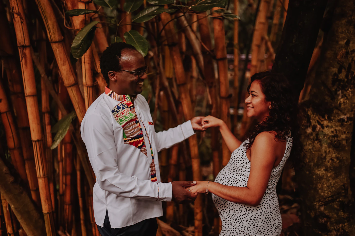 Couple in elopement attire at Cocalito beach near Nuqui Colombia with the primary Choco rainforest covering the hills and the shoreline completely surrounding them