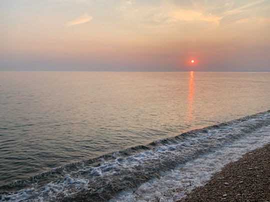 ocean waves crashing on shore during sunset in Chesil Beach United Kingdom