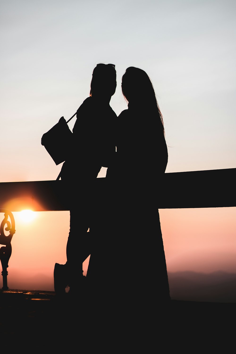 Silueta de pareja besándose durante la puesta del sol