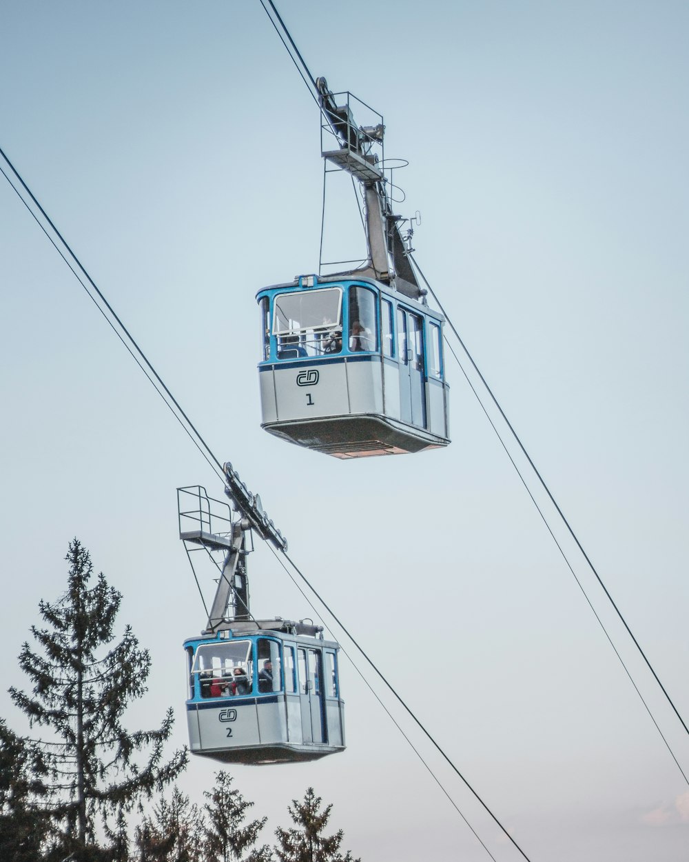 white and blue cable car under white sky