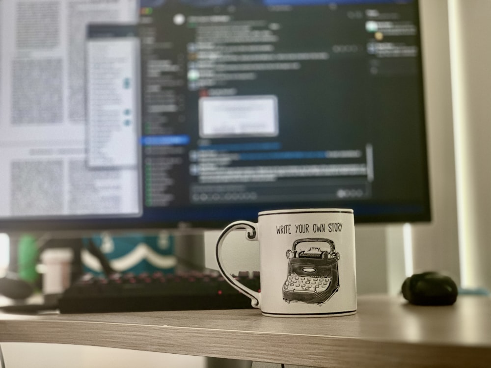 white and black ceramic mug beside black computer mouse