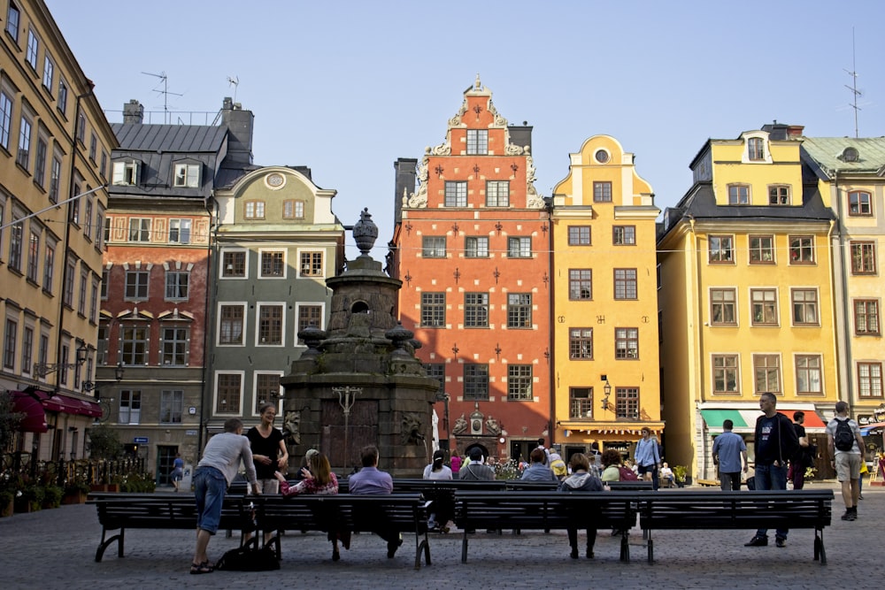 people sitting on bench near brown concrete building during daytime