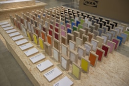 A variety of colorful signage samples displayed on a workshop table, ready for installation.