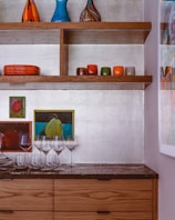 A bright kitchen with open shelves and colorful accessories.