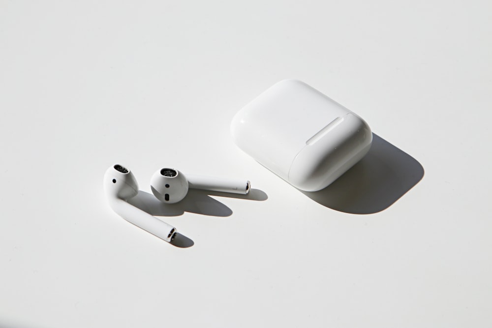 apple earpods beside apple airpods