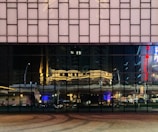 Wide shot of a storefront with polished ACM cladding reflecting city lights.
