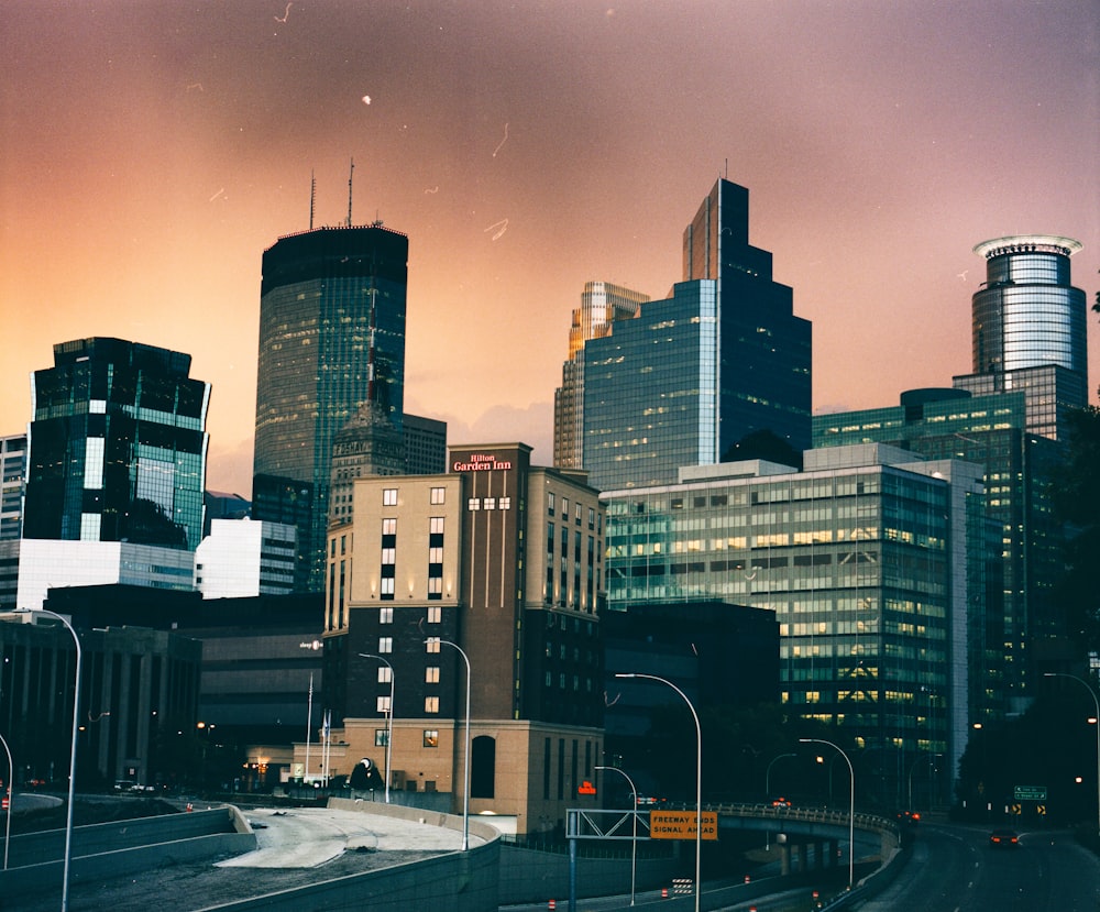 cars on road near high rise buildings during daytime