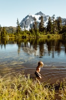 woman in black long sleeve shirt and black pants running on water during daytime