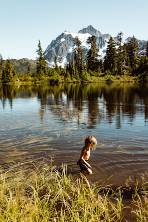 woman in black long sleeve shirt and black pants running on water during daytime