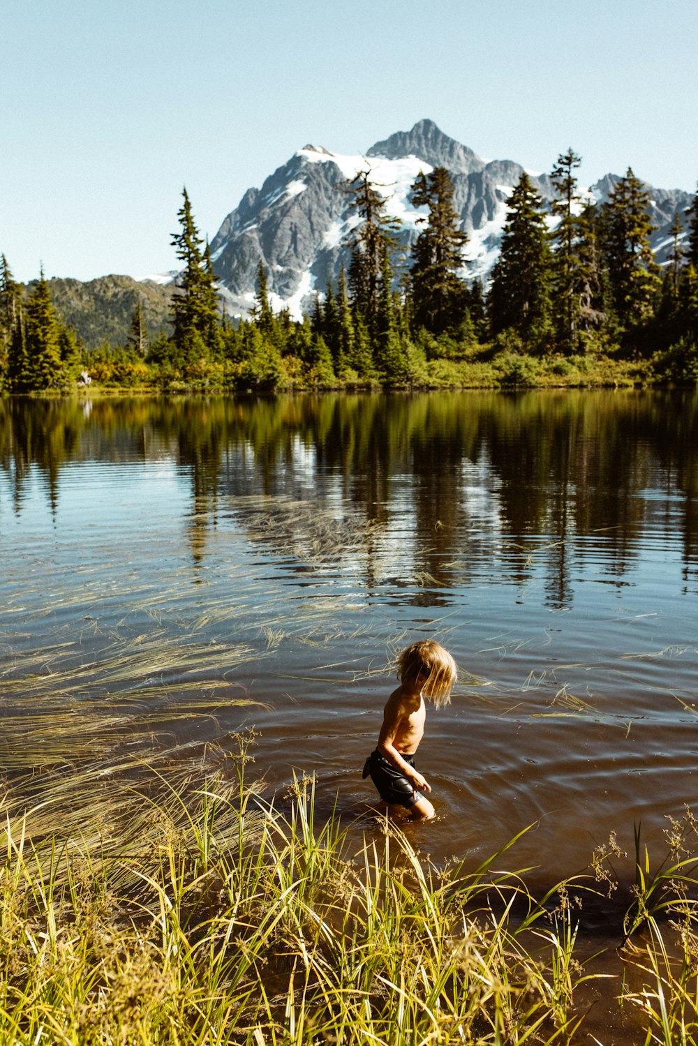 woman in black long sleeve shirt and black pants running on water during daytime