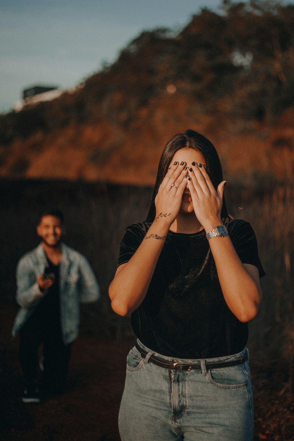 woman in black t-shirt covering her face with her hands