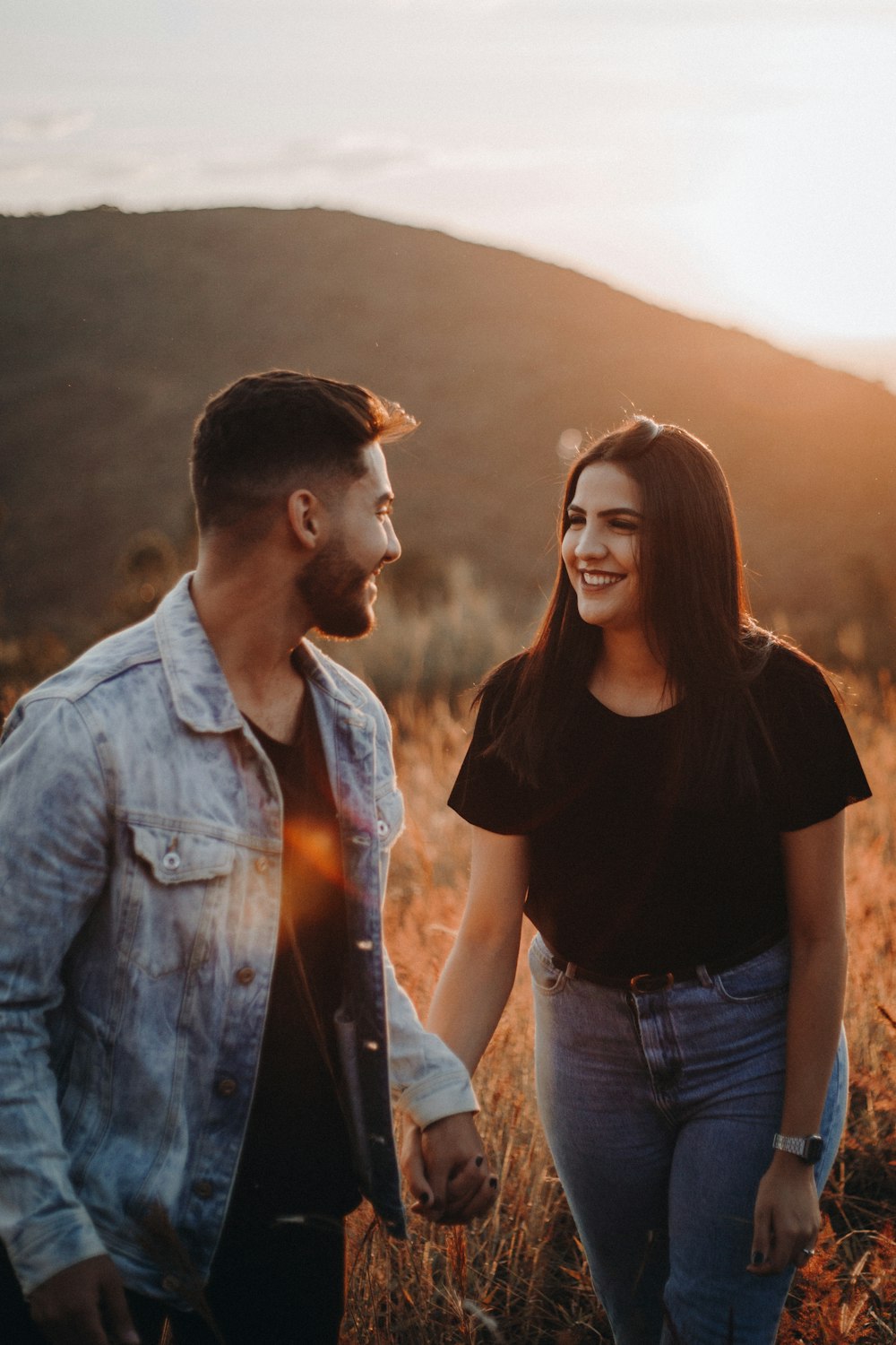 man in blue denim button up jacket standing beside woman in black shirt