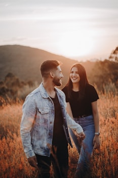 man in blue denim button up shirt standing beside woman in black shirt
