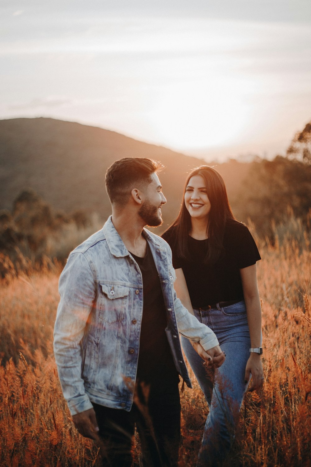 man in blue denim button up shirt standing beside woman in black shirt