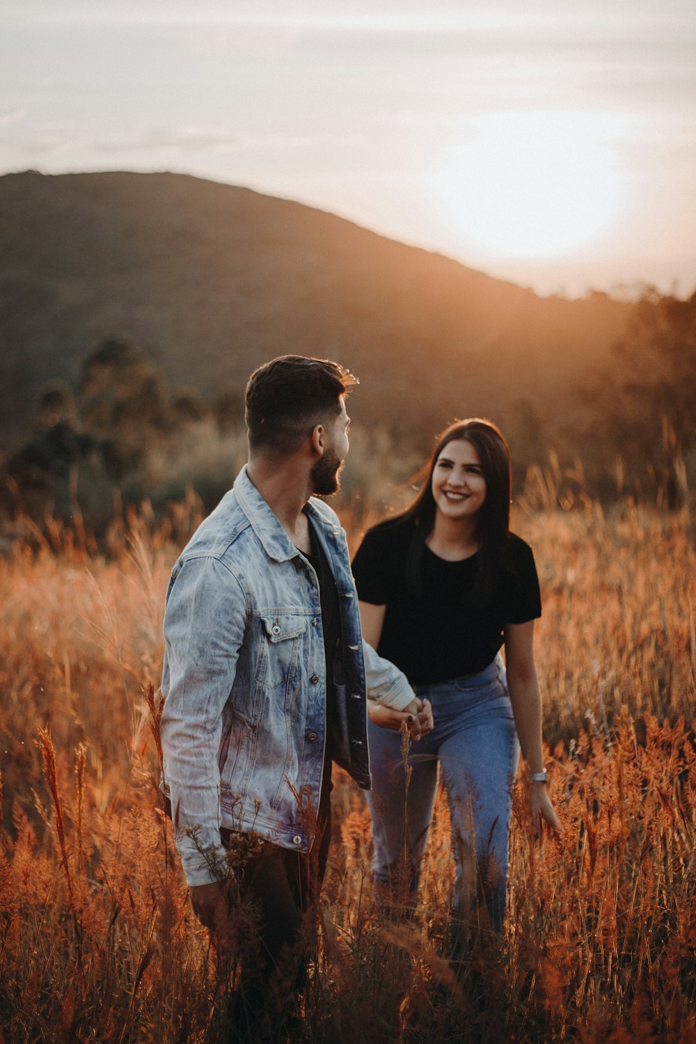 man in gray button up jacket standing beside woman in black shirt