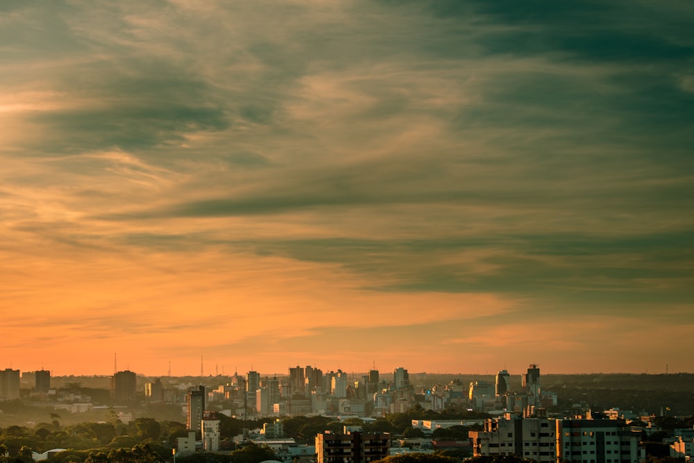 horizonte da cidade sob céu nublado durante o pôr do sol