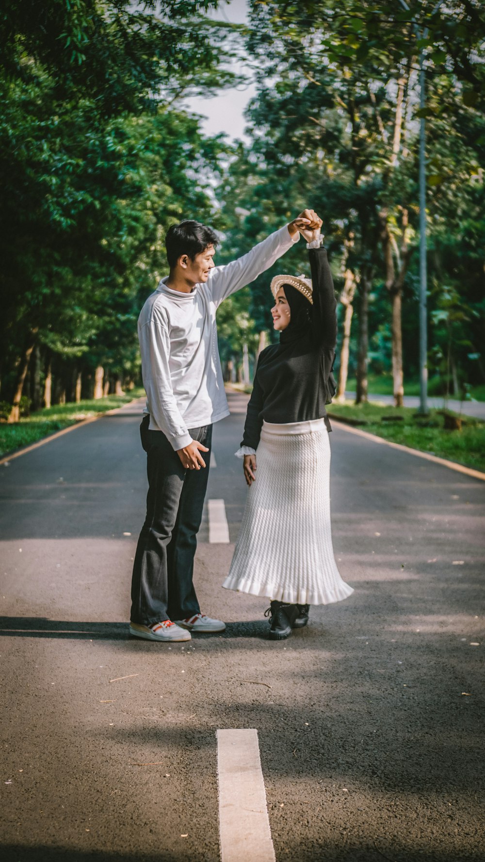 man in white long sleeve shirt and black pants holding woman in black dress