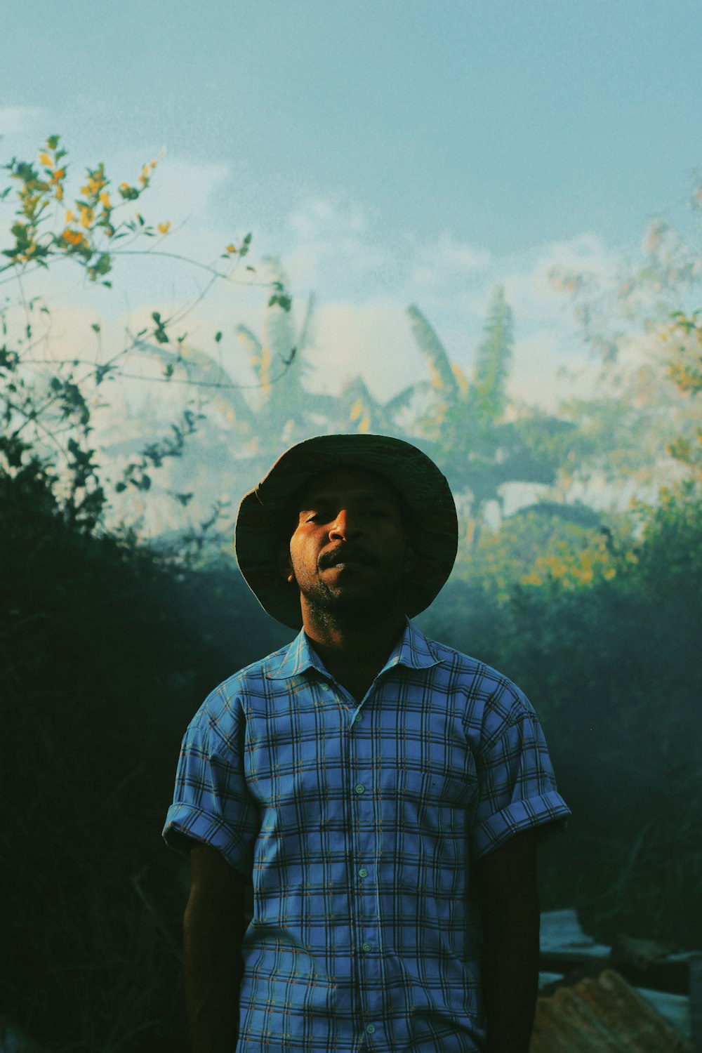 man in blue and white plaid button up shirt wearing black hat