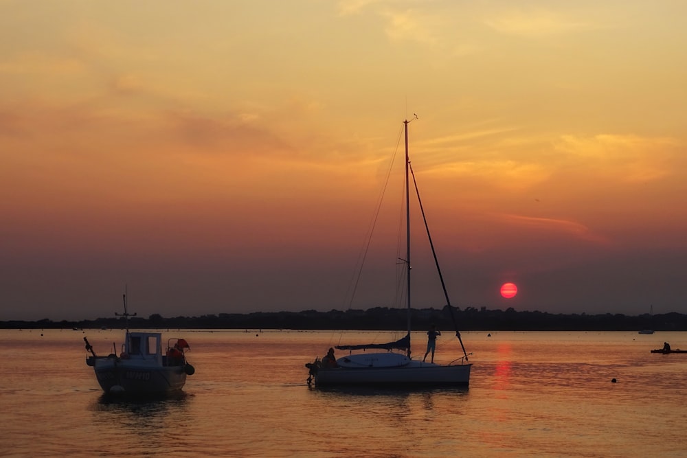 silhouette of boat on sea during sunset