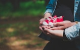 person holding white and red heart ornament
