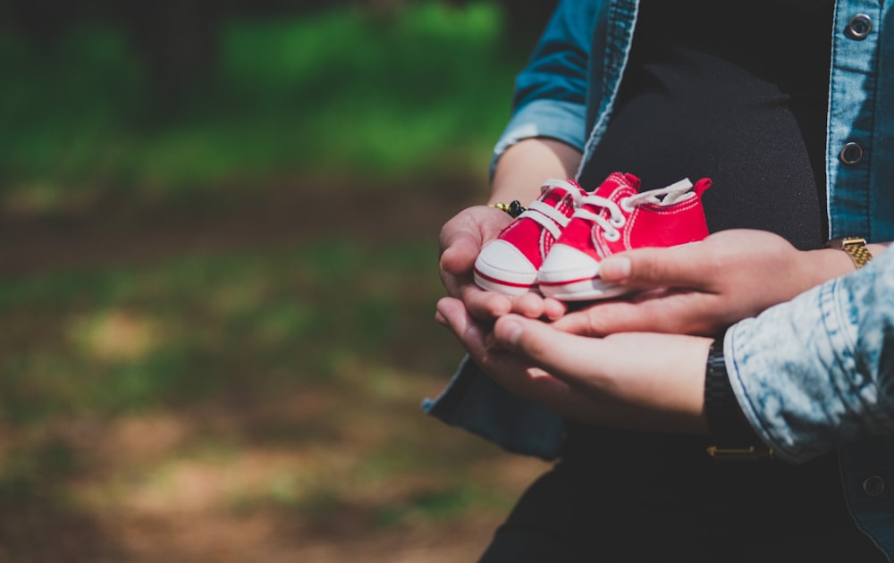 person holding white and red heart ornament