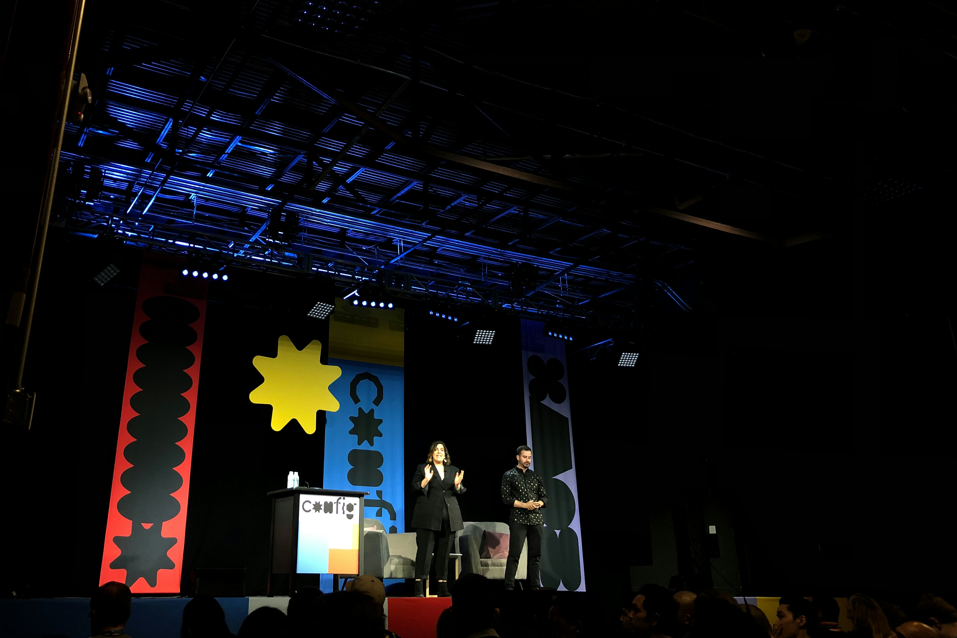 people standing on stage with red yellow and blue star flag