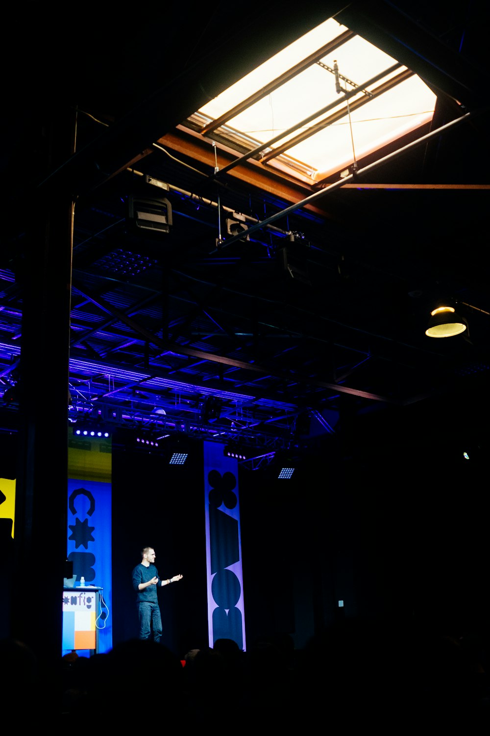 man in white shirt standing on stage