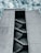 A large, concrete building with the words 'Faculty of Engineering' inscribed at the top. The building features an external staircase zigzagging up the facade, visible through a tall, narrow vertical opening. The sky is partly cloudy, providing a dramatic backdrop.