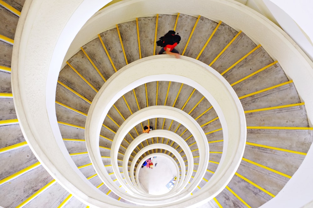 person in black jacket standing on spiral staircase