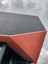 red and black concrete building under white clouds during daytime