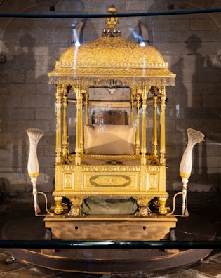 A golden throne adorned with intricate carvings and shining jewels, bathed in warm light.